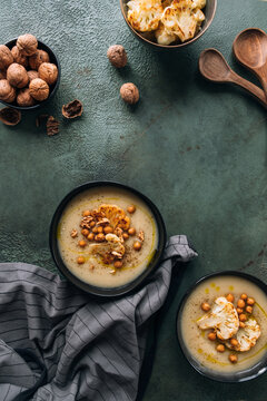 Cauliflower creamy soup topped with roasted cauliflower, chickpeas and walnuts