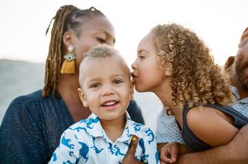Girl whispers into younger brother's ear 