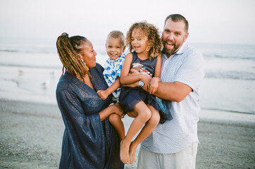 Happy biracial family together on beach