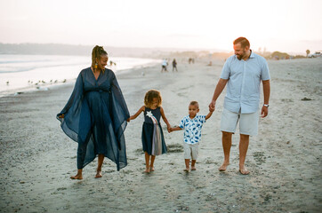 Biracial family walking on beach