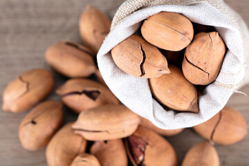 A bag of pecans and scattered pecans