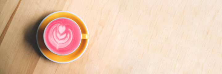 Banner with cup of trendy beetroot latte on table.