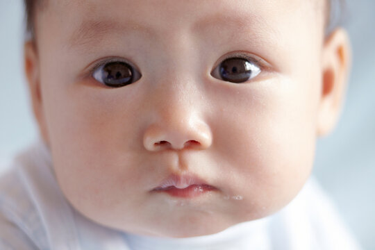 Close-up of a cute Asian baby playing on the bed