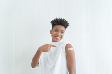 Portrait of happy young black African American teenager showing an arm with plaster after...