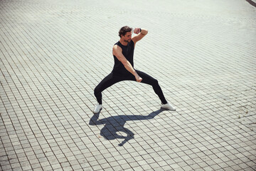 Active brunette man doing sport on square