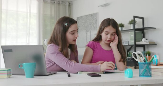 Girl helping her younger sister with her homework