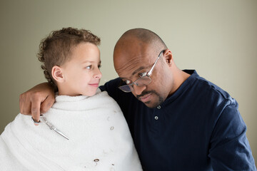 Father shows son his own balding head during haircut