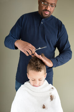 Curls fall as father trims son's hair