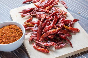 Cayenne pepper in white ceramic bowl , Dry red chili on plate wood.