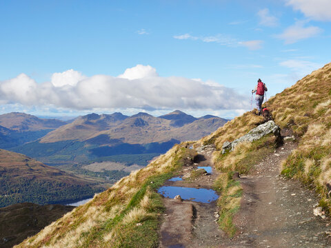 Female and her dog climbing Ben Lomond. Loch Lomond, Scotland.