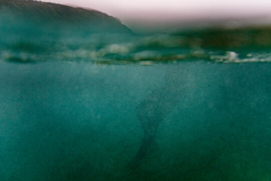 Silhouette of surfer into the water on winter day