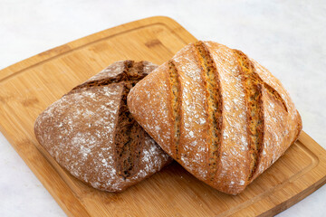 Hot bread fresh from the oven. Wheat bread on wooden background