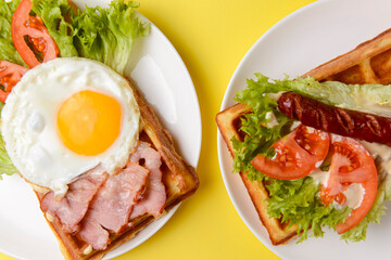 Waffle wholesome breakfast. Sour waffles with grilled sausages, fried eggs, delicious sauce and fresh vegetables.