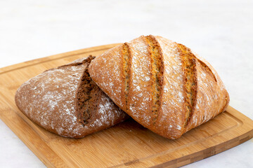 Hot bread fresh from the oven. Wheat bread on wooden background