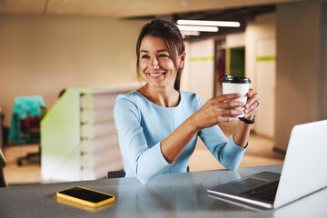 Young attractive charming female business analyst in formal wear working in luxury office interior