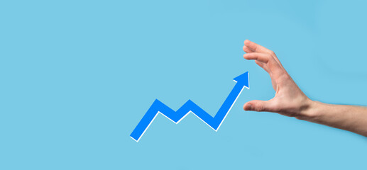 Hand hold drawing on screen growing graph, arrow of positive growth icon.pointing at creative business chart with upward arrows.Financial, business growth concept.