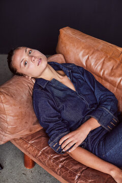 Young woman relaxing on a leather sofa