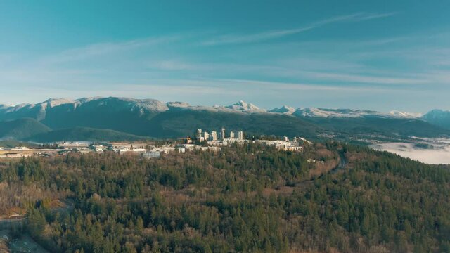 Aerial view of Simon Fraser University on a hill and mountains on background in British Columbia, Canada