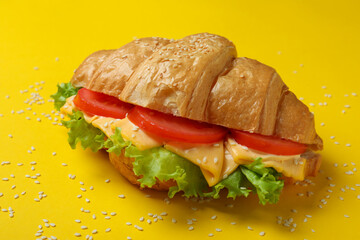Tasty croissant sandwich on yellow background, close up