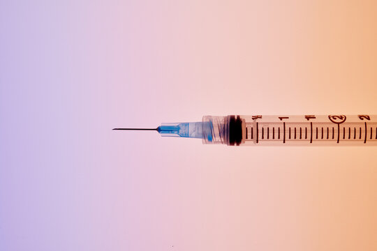 Medical Syringe on Blue-Orange Background