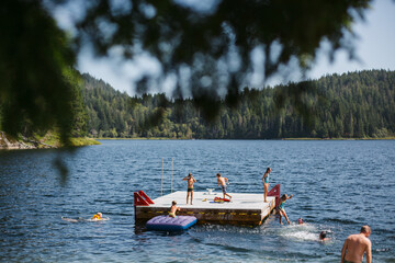 Kids playing on floating dock in summer lake