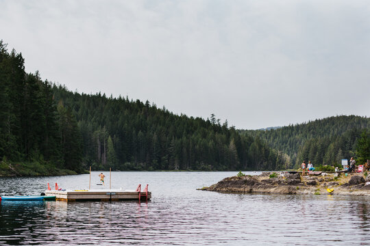 Kid jumping over high bar into summer lake