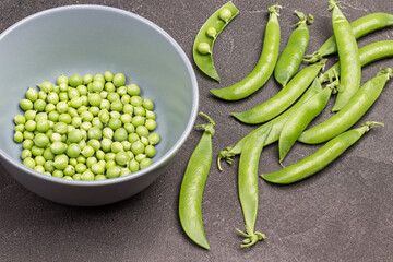 Peeled green peas in gray bowl.