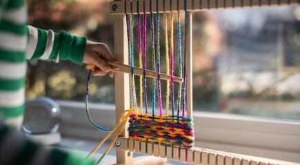 Child weaving on loom