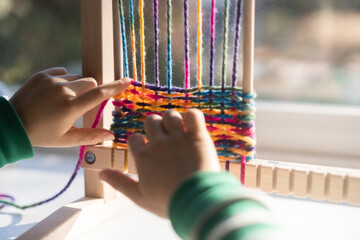 Child doing craft with yarn