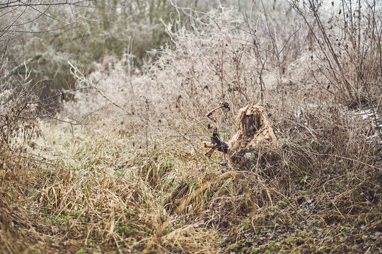 Bow hunter in ghillie suit