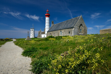 Fototapeta na wymiar phare blanc et rouge de la pointe Saint Mathieu et son Abbaye du Finistère en ruine sous un ciel bleu de Bretagne 