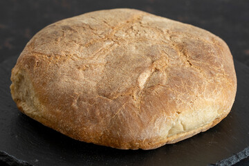 Organic round bread on a dark wooden background