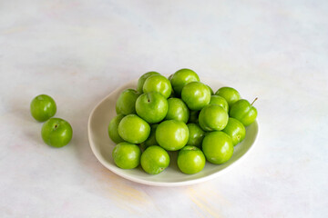 Green plum on a white background.