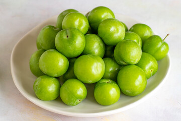 Green plum on a white background.