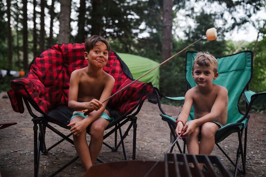 Roasting marshmallow on campsite in bathing suit