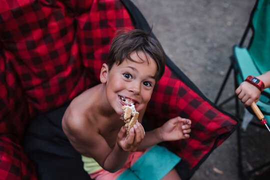 Roasting marshmallow on campsite in bathing suit