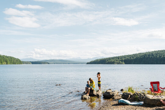 Kids Hanging Out By Lake In Summer