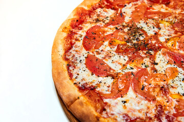 Pizza with tomatoes, cheese and spices on a wooden board and white background