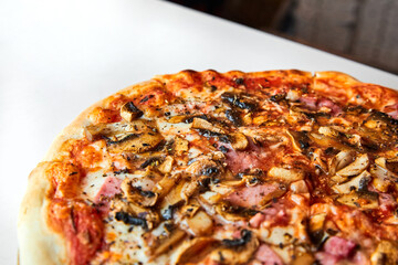 Fresh pizza with bacon, mushrooms and cheese on a light background. Close-up, selective focus