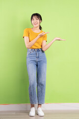 Full body portrait of young asian girl on green background
