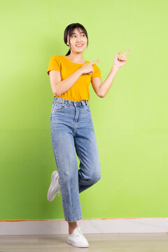 Full Body Portrait Of Young Asian Girl On Green Background