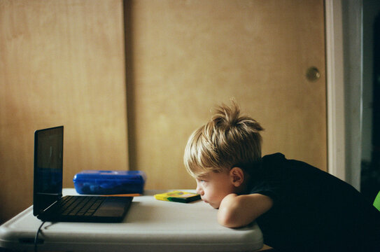 Young boy staring at computer during  distance learning kindergarten 