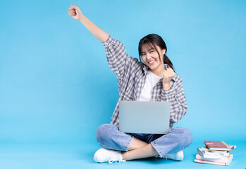 Asian female student with playful expression on blue background