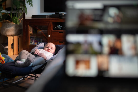Laptop and baby in swing chair.