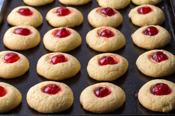 Cherry cookies on baking tray - delicious cherry topped cookies