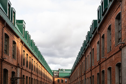 Fototapeta Perspective of red brick buildings with green roof in a sunny day