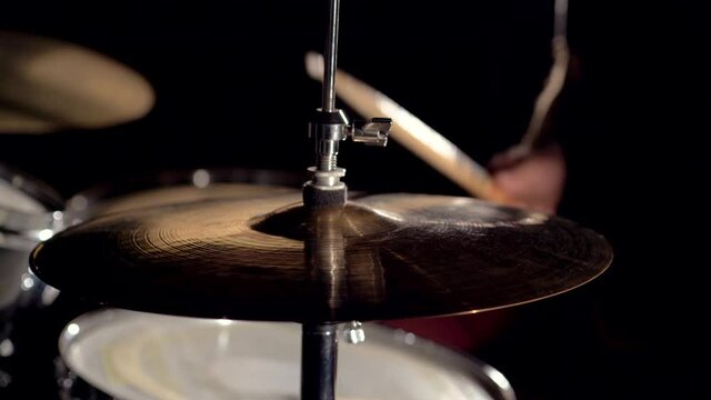 Hands of musician drummer holding drum sticks hitting on hi-hat cymbal