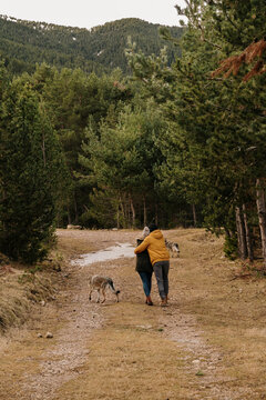 Couple with wolf dogs walking on a forest path