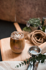 iced coffee in iridescent stemless glass served on black table at cafe​