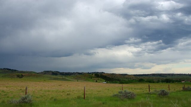 Storm clouds moving over the Montana landscape in timelapse with traffic in the distance.
